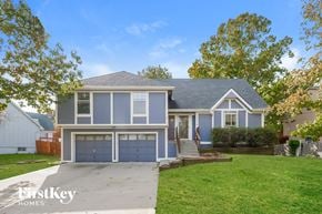 Olathe house for rent - A blue house with a white garage door is for sale.