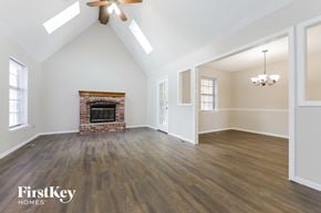 Olathe house for rent - A spacious room with a fireplace and wooden floors.