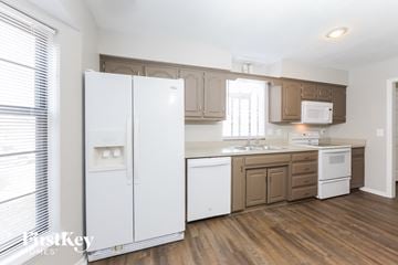 Olathe house for rent - A kitchen with white appliances and wooden floors.