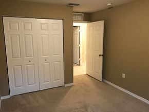Homestead house for rent - a bedroom with two closets and two doors and a carpeted floor