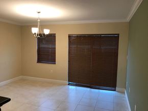 Homestead house for rent - a dining room with a large window and a door to a living room