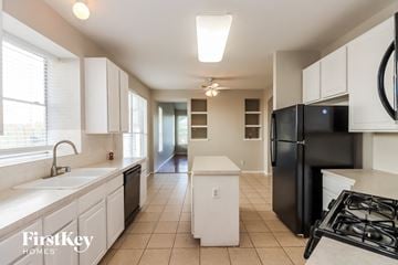 Houston house for rent - a kitchen with white cabinets and a black refrigerator
