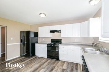 Black Jack house for rent - a white kitchen with black appliances and white cabinets