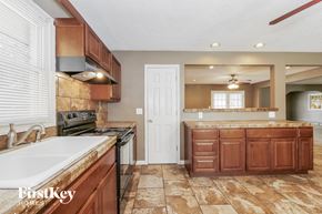Independence house for rent - a kitchen with wooden cabinets and a sink and a stove