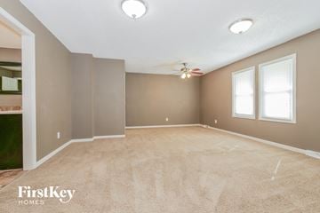 Independence house for rent - a spacious living room with carpet and a ceiling fan