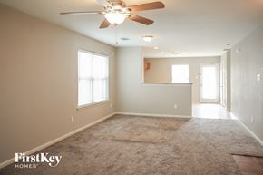 Houston house for rent - a empty living room with a ceiling fan and a carpet