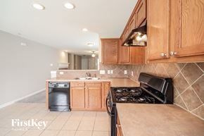 Houston house for rent - a kitchen with wood cabinets and a stove and a sink