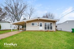 Florissant house for rent - A house with a green lawn and a sign that says FirstKey Homes.