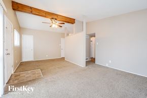 Florissant house for rent - A spacious room with a ceiling fan and a rug on the floor.