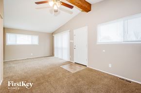 Florissant house for rent - A spacious room with a ceiling fan and carpeted floor.