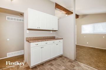 Florissant house for rent - A kitchen area with white cabinets and a countertop.