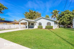 Dania Beach house for rent - A white house with a green lawn in front of it.