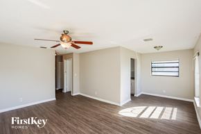 Dania Beach house for rent - A room with a ceiling fan and wooden flooring.