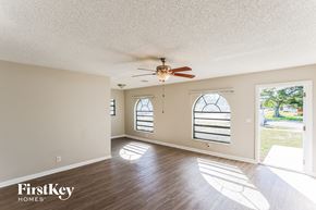 Dania Beach house for rent - A room with a ceiling fan and two windows.