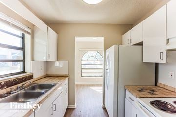 Dania Beach house for rent - A kitchen with white cabinets and a stainless steel sink.