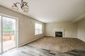Fishers house for rent - an empty living room with a fireplace and a sliding glass door