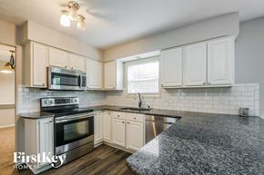 Fishers house for rent - a kitchen with granite counter tops and white cabinets