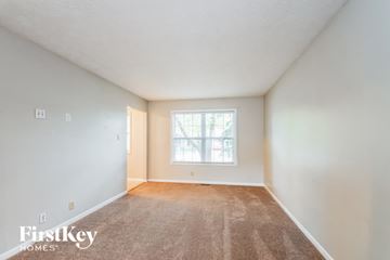 Fishers house for rent - a spacious living room with carpet and a window