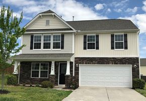 Greensboro house for rent - A two-story house with a garage door and a front porch.