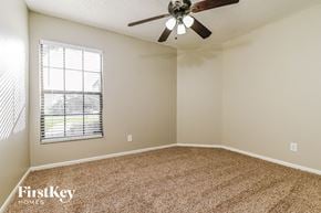 Valrico house for rent - a bedroom with a ceiling fan and a window