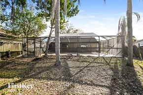 Valrico house for rent - a house with a yard with trees and a fence