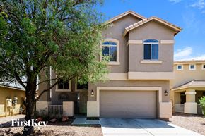 Surprise house for rent - a house with a garage door and a tree