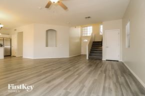 Surprise house for rent - an empty living room with wood flooring and a staircase