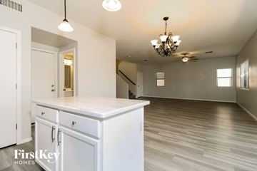 Surprise house for rent - a kitchen and living room with white cabinets and a chandelier