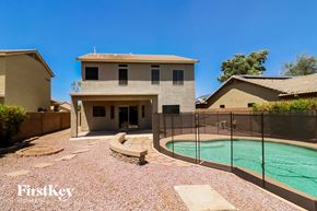Surprise house for rent - a house with a pool and a fence in front of it