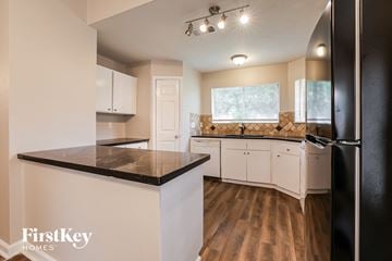 Houston house for rent - A kitchen with a black counter top and white cabinets.