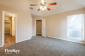 Houston house for rent - A spacious room with a ceiling fan and a window with blinds.
