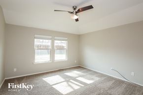 Royse City house for rent - an empty room with a ceiling fan and two windows