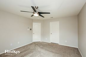 Royse City house for rent - a bedroom with a ceiling fan and a carpeted floor