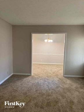 Conyers house for rent - an empty room with a carpeted floor and an open door