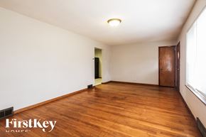 Indianapolis house for rent - A room with wooden floors and a door on the right side.