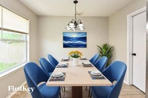 Houston house for rent - A dining room with a wooden table and blue chairs.
