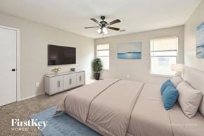 Houston house for rent - A bedroom with a bed, a ceiling fan, and a television.