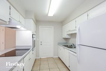 Tempe house for rent - A kitchen with white cabinets and a white refrigerator.