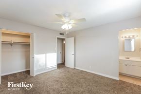 Tempe house for rent - A spacious bedroom with a carpeted floor and a ceiling fan.