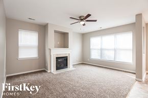 Huntersville house for rent - a living room with a fireplace and a ceiling fan