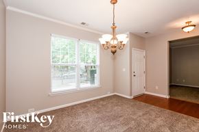 Huntersville house for rent - an empty dining room with a large window and a chandelier