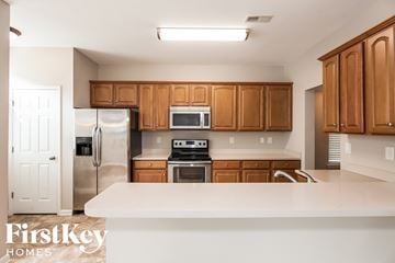 Huntersville house for rent - a kitchen with wooden cabinets and stainless steel appliances