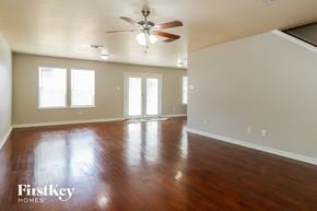 Houston house for rent - A spacious room with wood flooring and a ceiling fan.