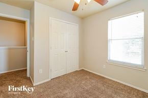 Houston house for rent - A bedroom with a white door and a window with blinds.