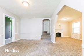 Grandview house for rent - A spacious room with a staircase leading to the second floor.