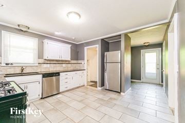 Grandview house for rent - A kitchen with a stove top oven and a refrigerator.