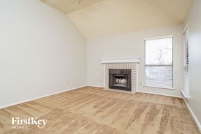 Lewisville house for rent - A room with a fireplace and a window with blinds.