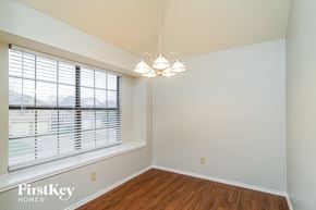 Lewisville house for rent - A room with wooden floors and a window with blinds.