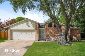 Houston house for rent - a brick house with a garage and a tree
