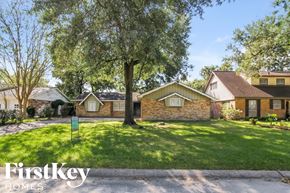 Houston house for rent - the front of a house with a lawn and a tree